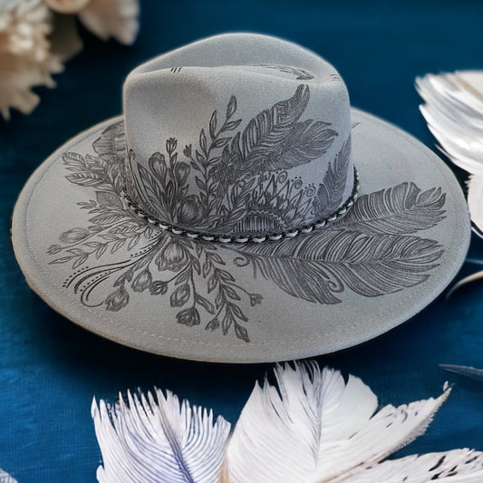 Front angled view of the Topknot hat showing crown artwork and decorative band