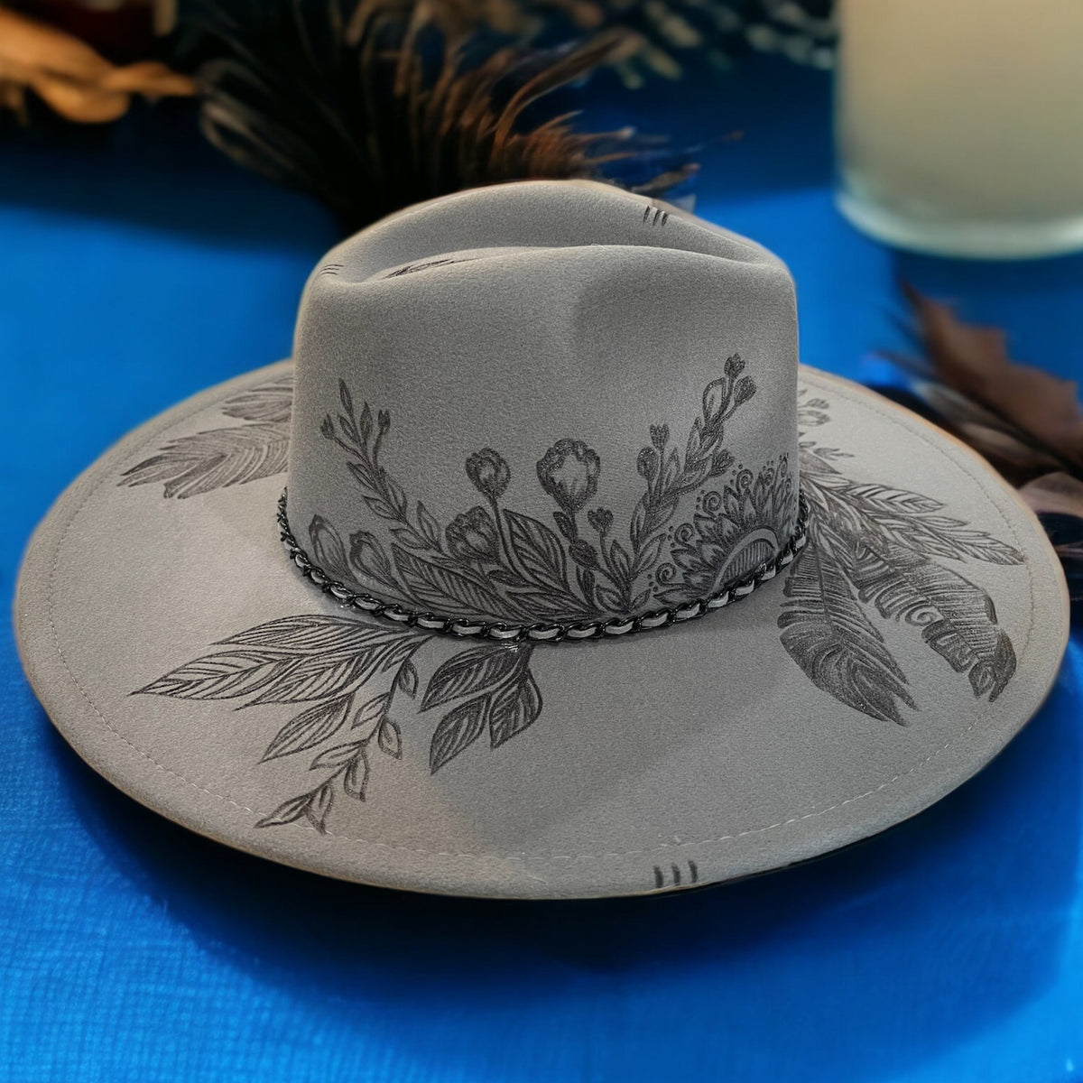 Opposite side of the grey Topknot hat showing leafy pyrography