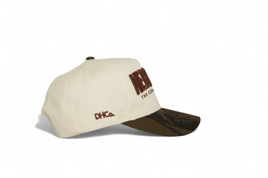 Side profile of the Destination Hat Co. Nebraska camo cap showing the curved bill and side logo
