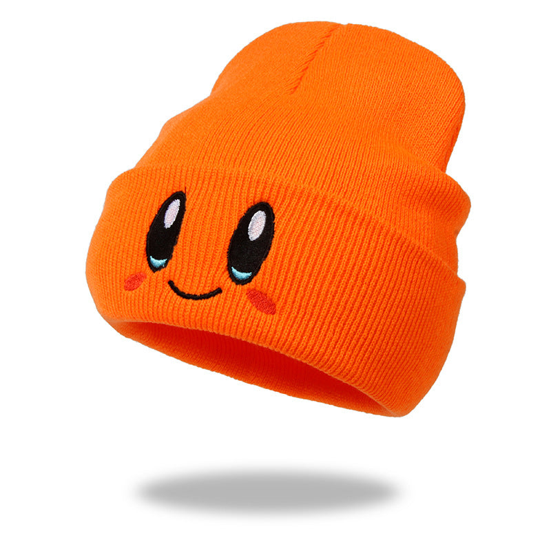 Orange knit beanie with smiling eyes and rosy cheek embroidery