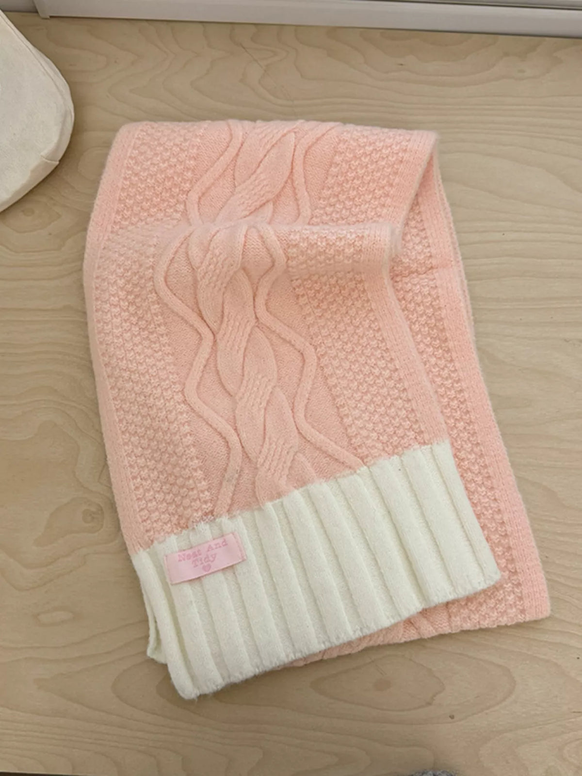 Unisex Two-Tone Cable Knit Scarf — folded pink scarf showing cable columns and pale ribbed end