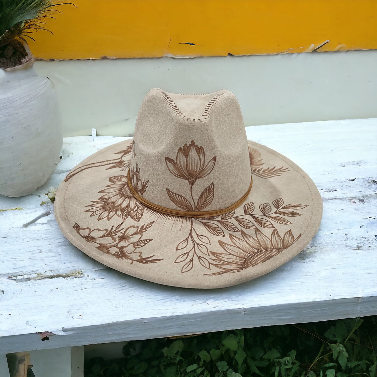 Piper Boho Luxe wide-brim hat with floral pyrography and a decorative band, angled view