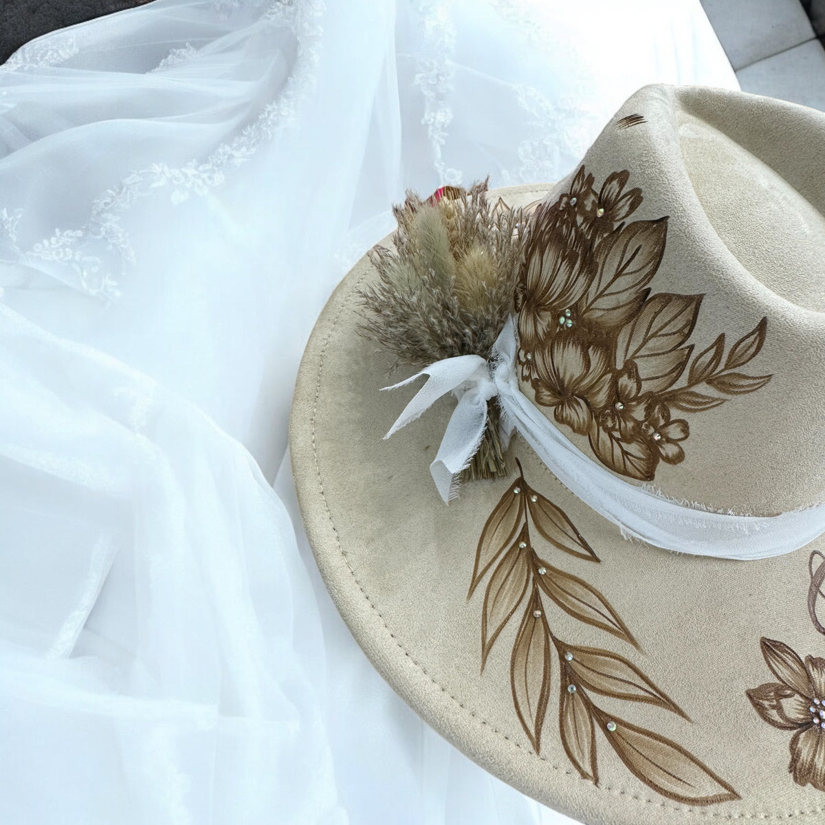 Angled detail of the bridal hat showing burned flowers and pale ribbon