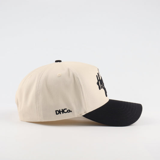 Side profile of the Destination Hat Co. Houston script cap showing the curved bill and side logo