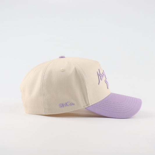 Side profile of the Destination Hat Co. Nacogdoches script cap showing the curved bill and side logo