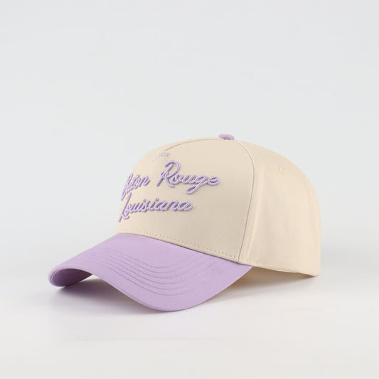 Opposite angled view of the Destination Hat Co. Baton Rouge script cap showing the purple lettering