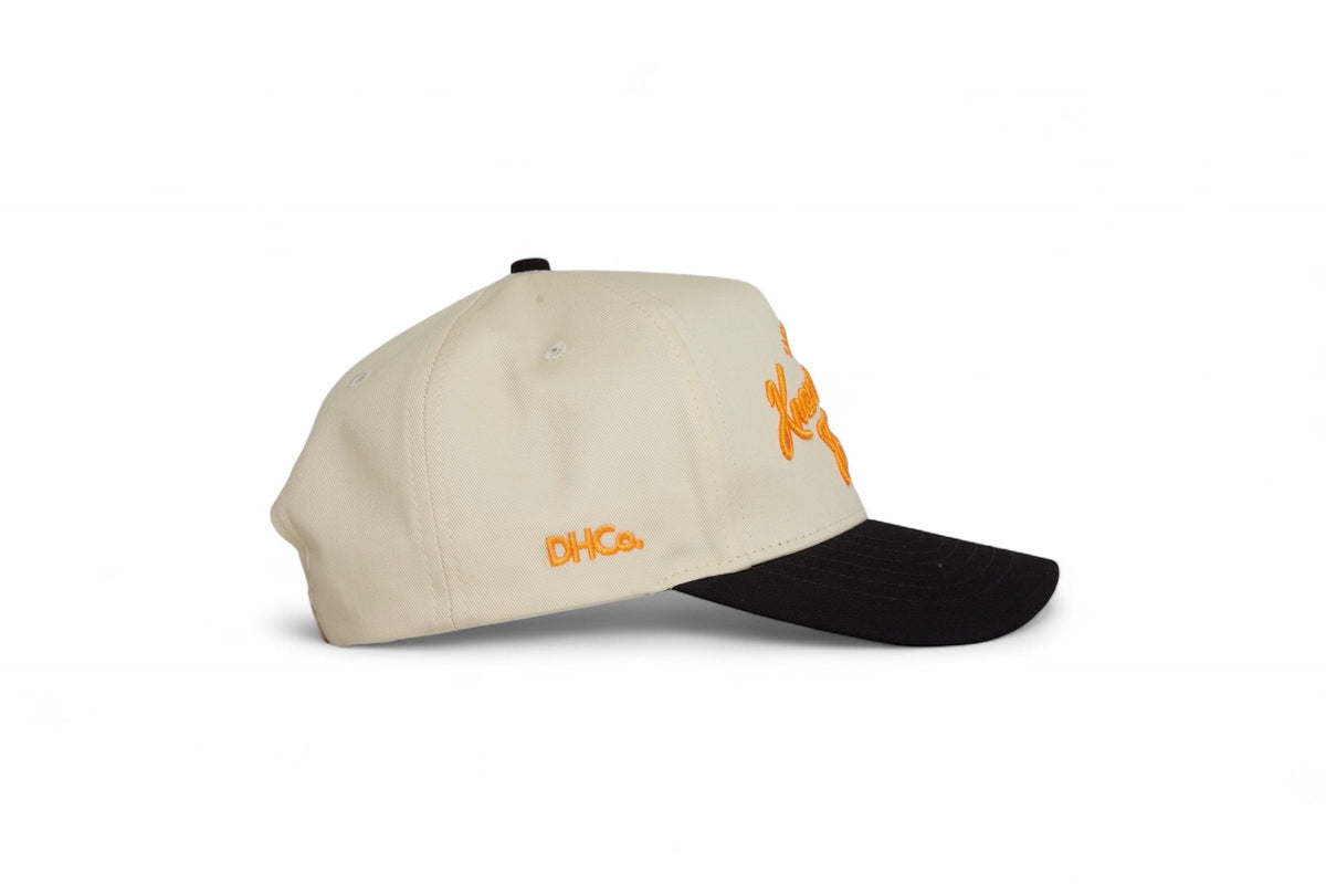 Side profile of the Destination Hat Co. Knoxville script cap showing the curved bill and side logo