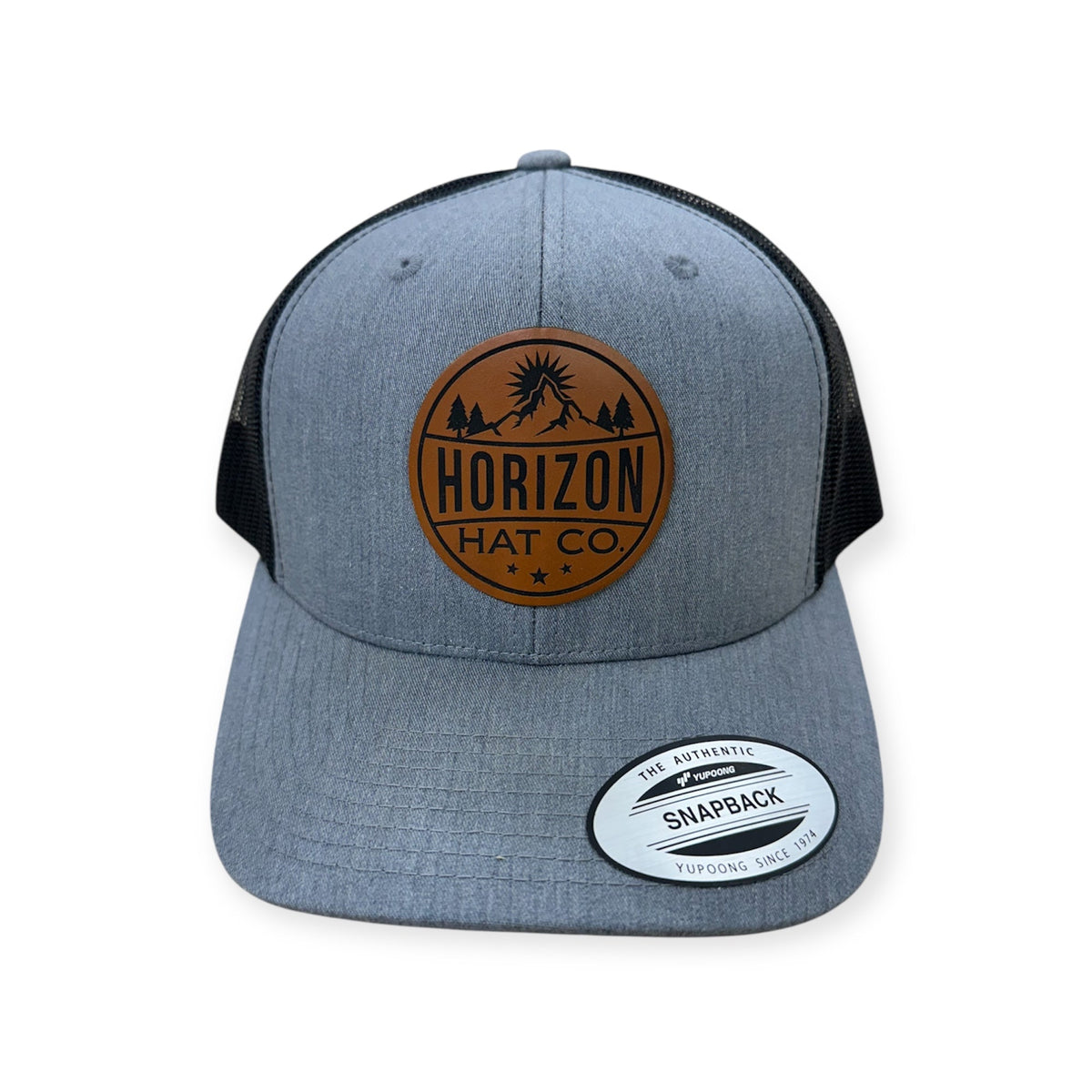 Heather gray and black Horizon cap with a round buckskin-colored logo patch