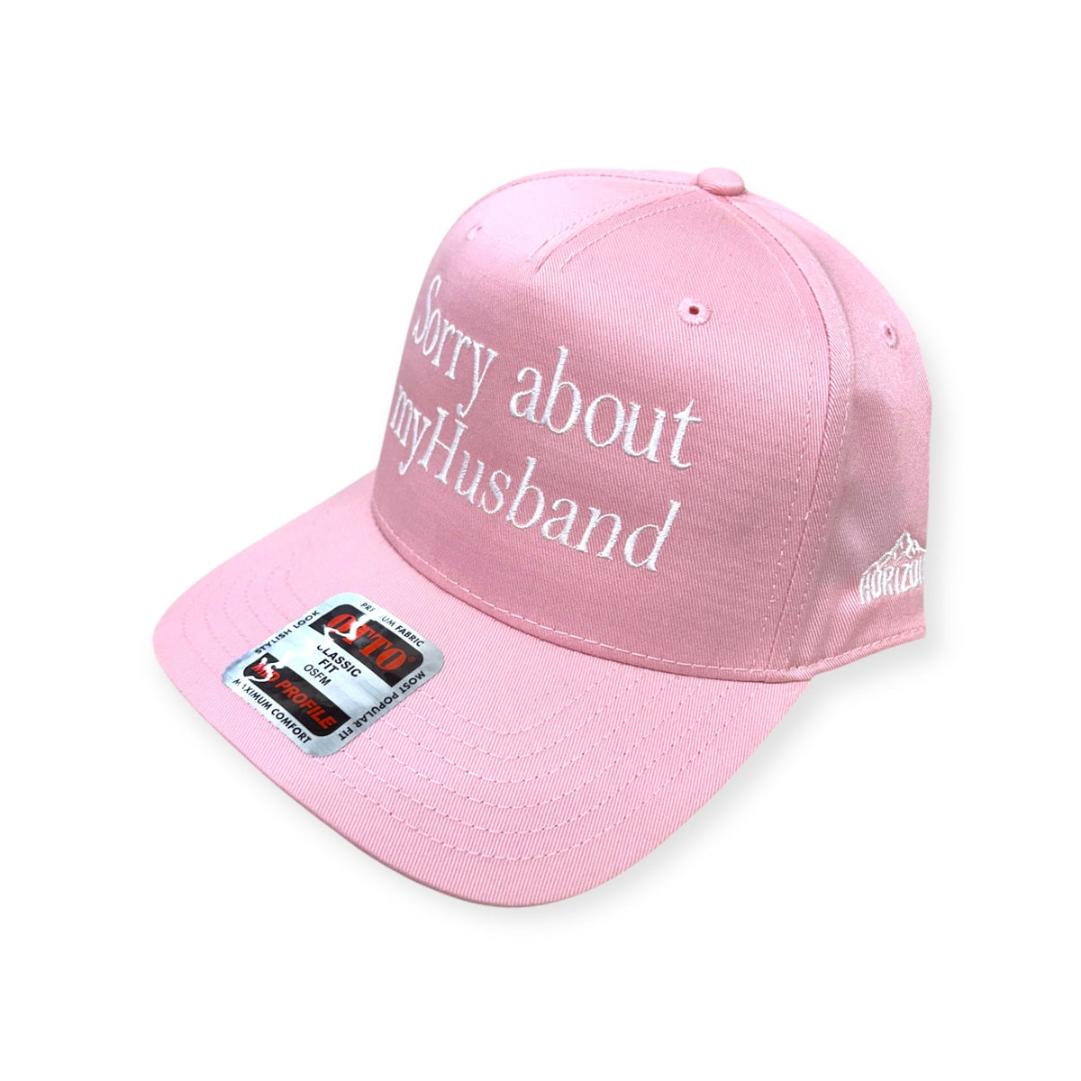 Angled view of Sorry About My Husband embroidered cap by Horizon Hat Co. in pink showing the bill and side panels