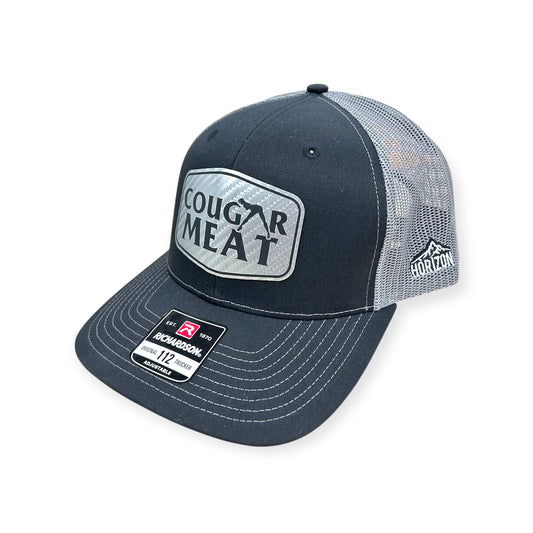 Angled view of Cougar Meat patch hat by Horizon Hat Co. in black/gray showing the curved bill and side panels
