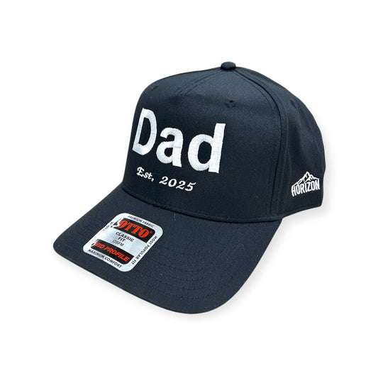 Angled view of Dad EST. 2025 embroidered cap by Horizon Hat Co. in navy/white showing the bill and side panels
