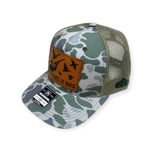 Angled view of If It Flies, It Dies patch hat by Horizon Hat Co. in camouflage showing the bill and side panels