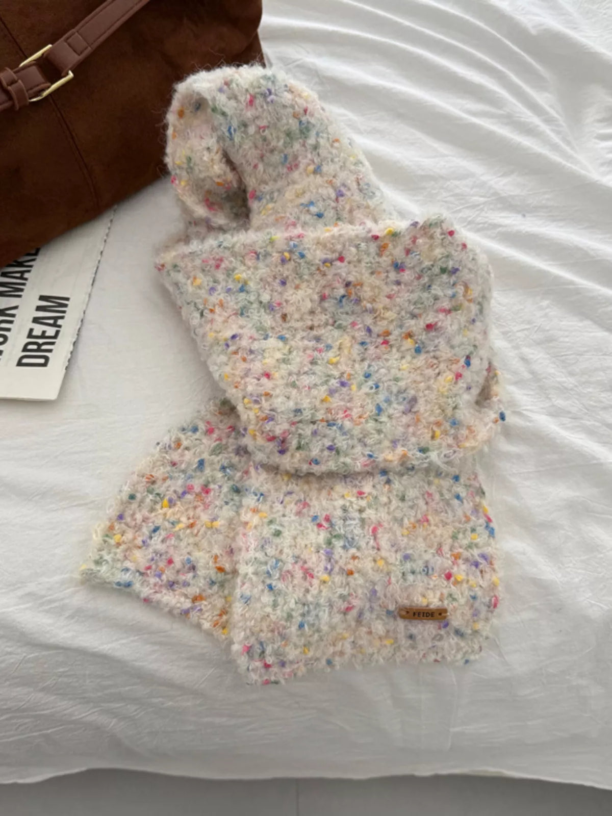 Unisex Multicolor Speckled Knit Scarf — pale speckled scarf loosely knotted on a neutral surface
