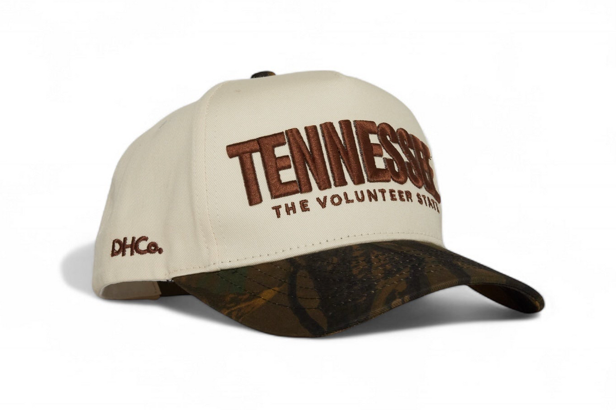 Destination Hat Co. Tennessee camo cap with beige crown and camouflage bill, angled view