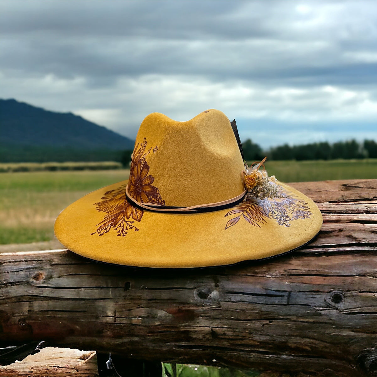 Side view of the mustard Aurelia hat against a mountain landscape