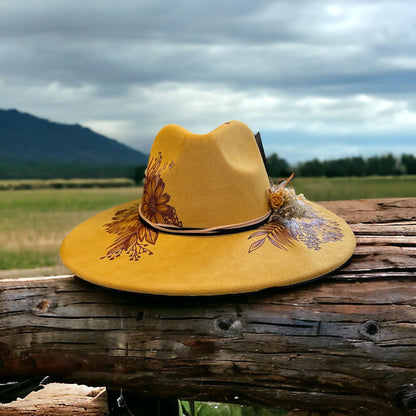 Side view of the mustard Aurelia hat against a mountain landscape