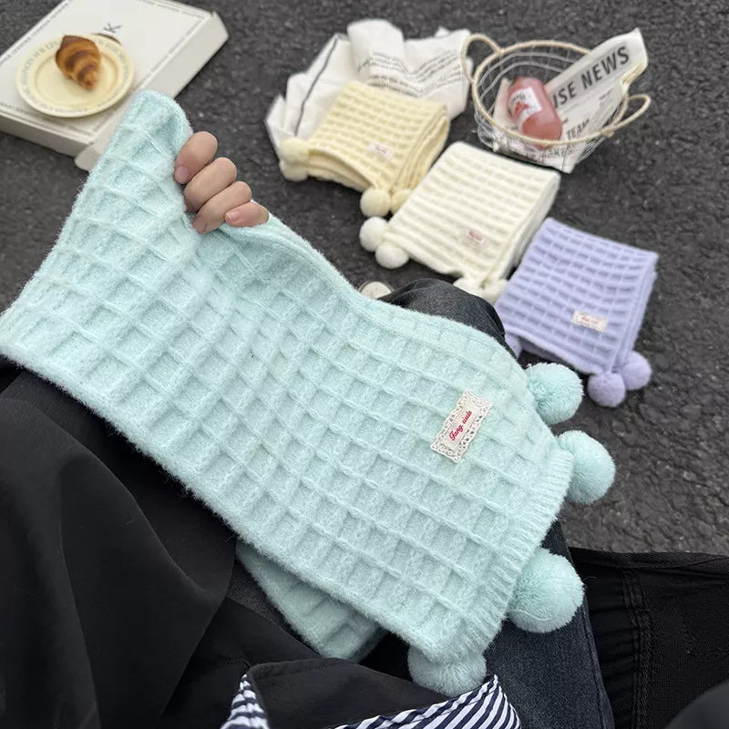 Unisex Waffle Knit Pom-Pom Scarf — hand holding the mint waffle scarf and pom-poms
