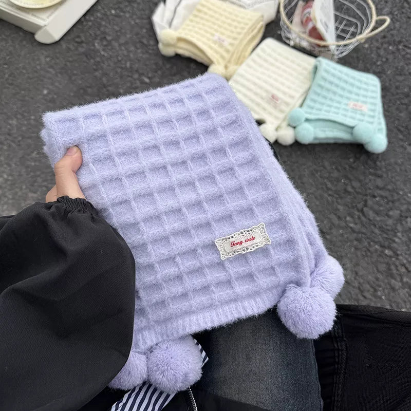 Unisex Waffle Knit Pom-Pom Scarf — hand holding a lavender scarf with grid knit texture
