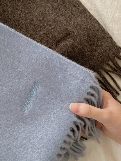 Unisex Azure Wool Fringe Scarf — hand holding the pale blue scarf surface