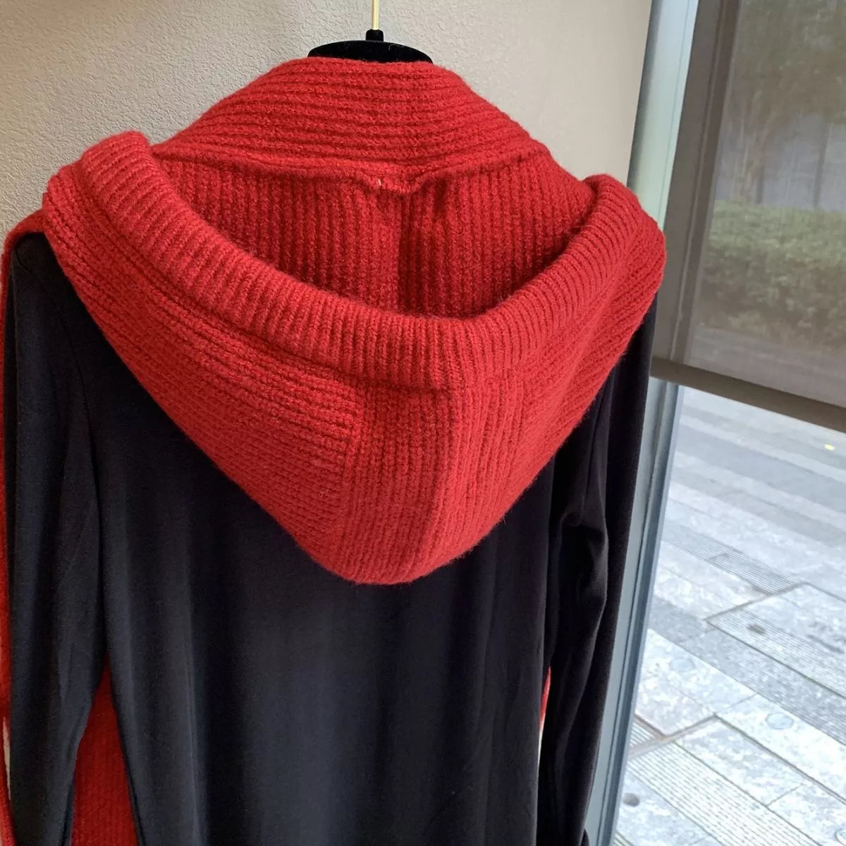 Unisex Hooded Tie Knit Scarf — red knitted hood displayed at the back of a jacket