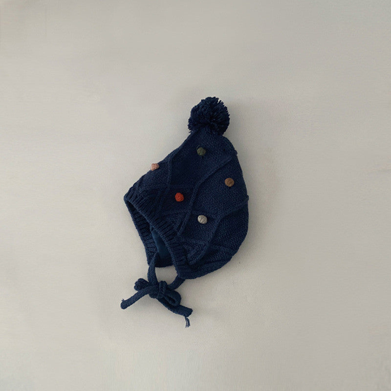 Navy cable-knit earflap bonnet with decorative buttons