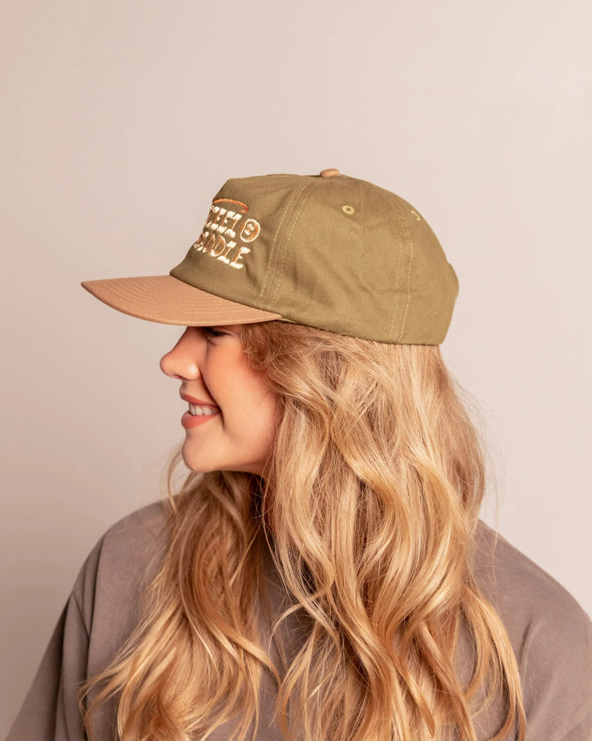 Opposite profile of the olive and rust brown Bass Hat on a model