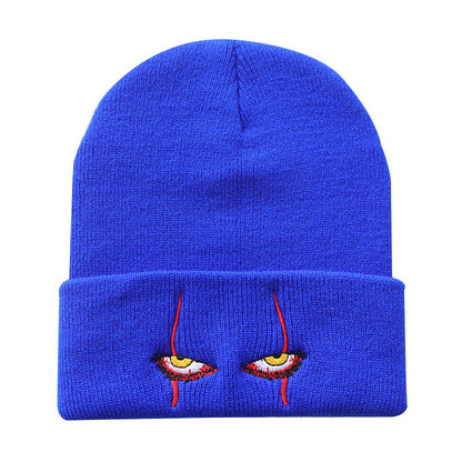 Blue knit beanie with narrow eyes and red embroidery
