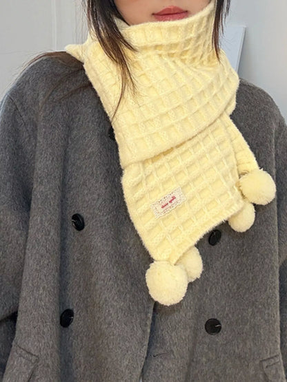 Unisex Pastel Waffle Knit Scarf — yellow pom-pom scarf worn over dark outerwear