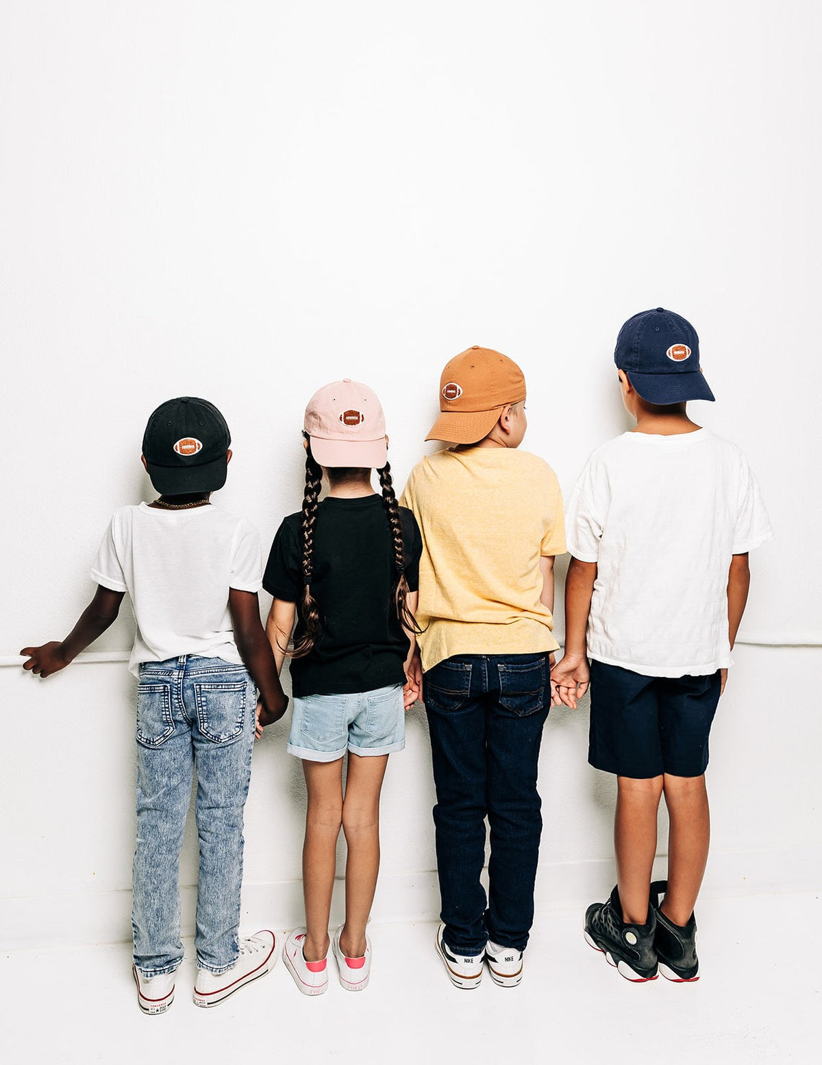 Rey To Z rear view of children wearing coordinated caps in several colors