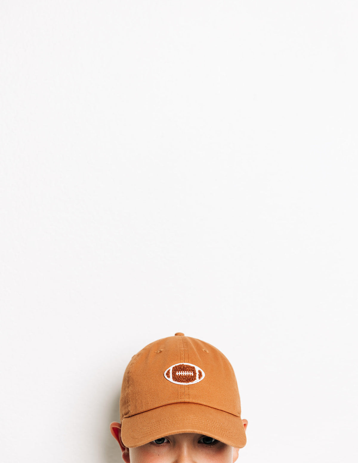 Rey To Z close view of the Terra Cotta football-patch cap worn by a child