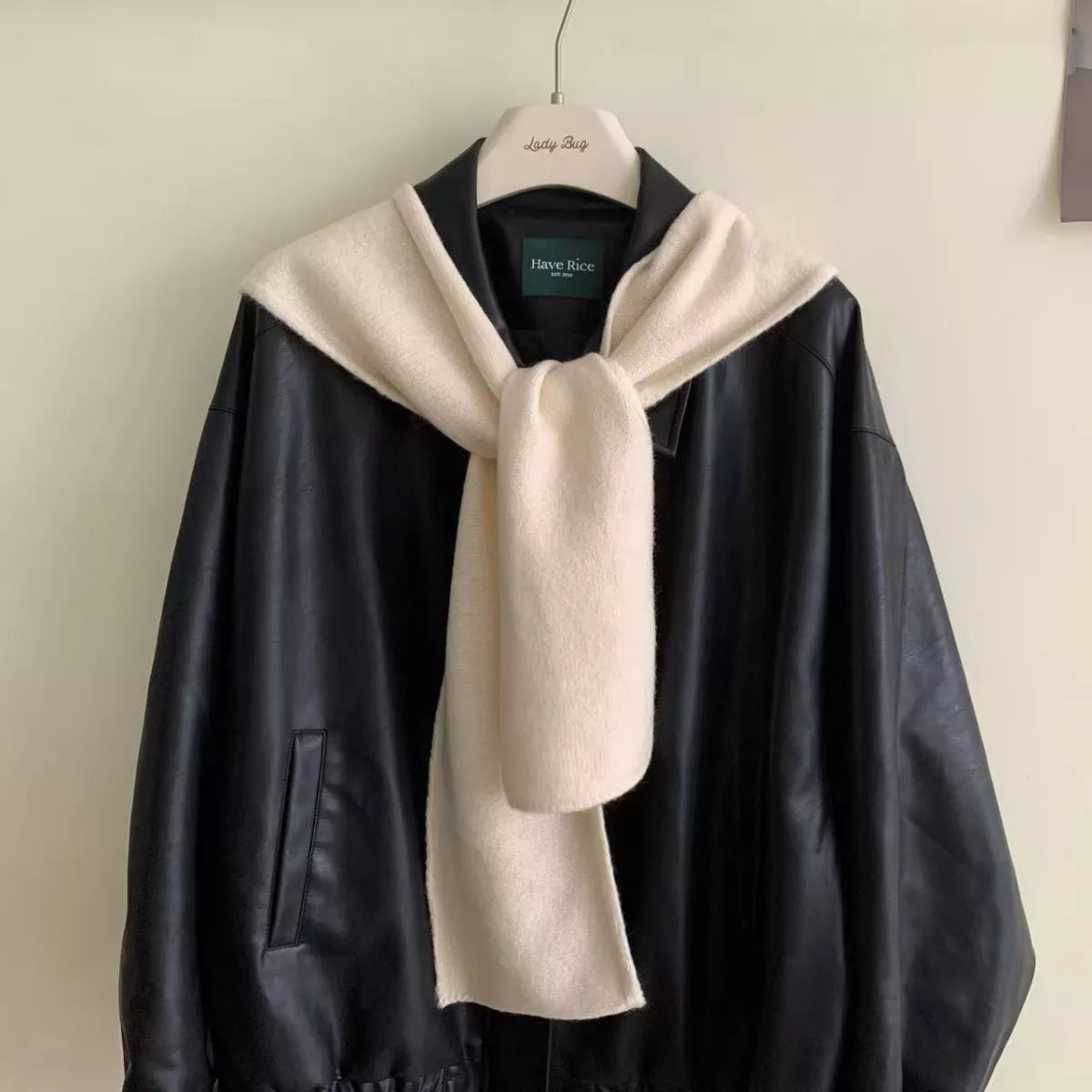 Unisex Knitted Hooded Scarf — beige hooded scarf worn over a dark jacket from the front