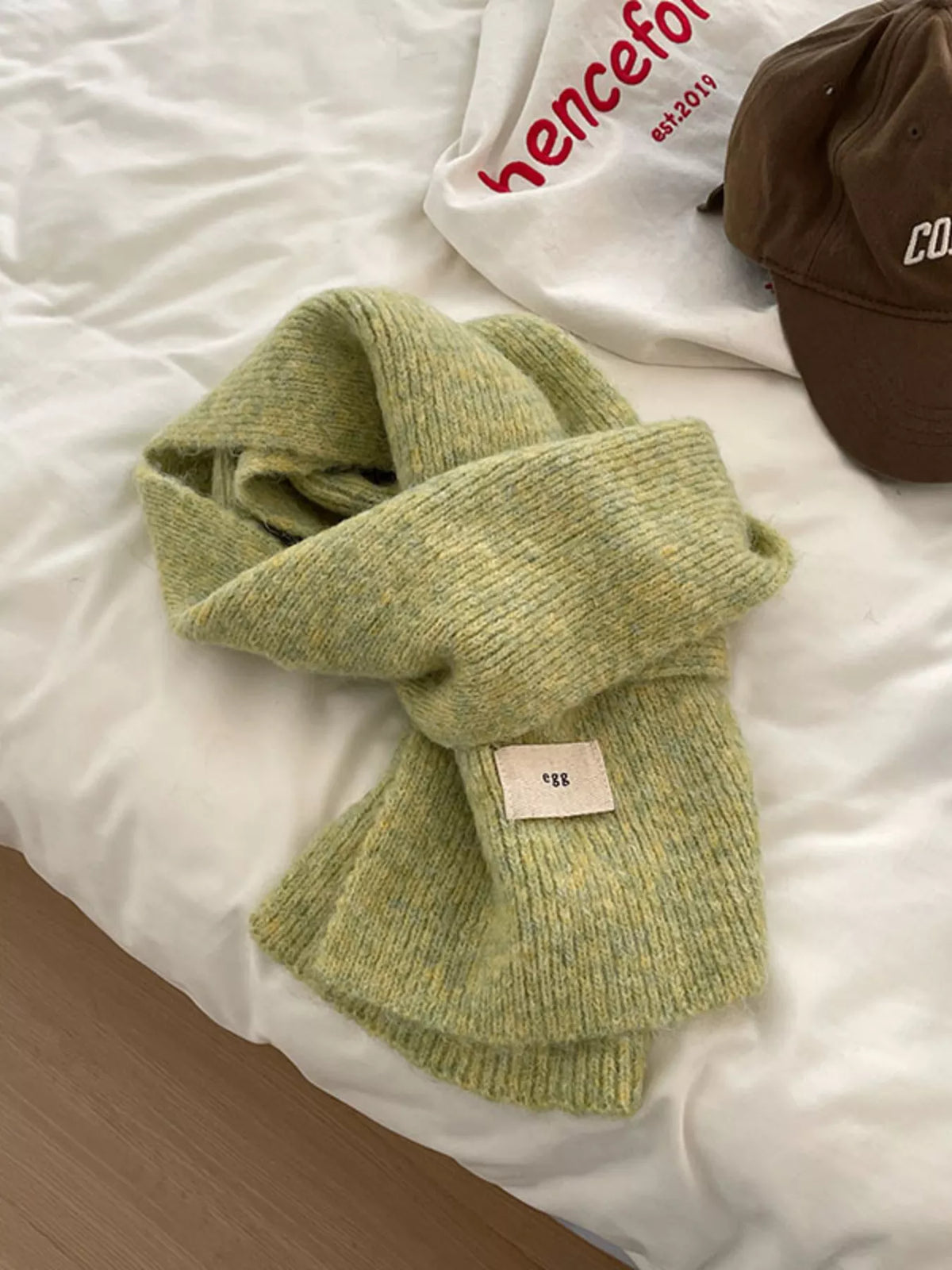 Unisex Fuzzy Solid Knit Scarf — green solid scarf loosely knotted on a pale surface
