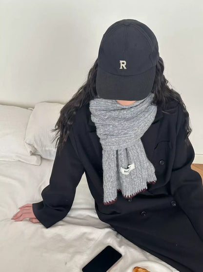 Unisex Cozy Cable Knit Scarf with Contrast Trim — gray scarf worn with a cap and dark casual layers