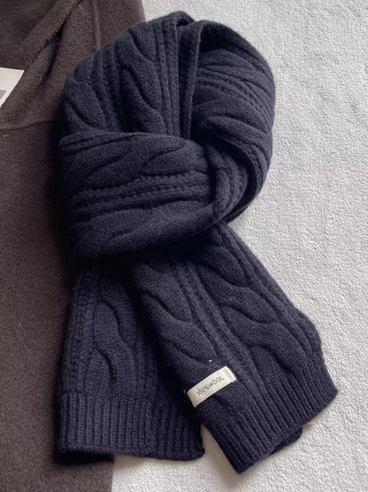Unisex Wool Cable Knit Winter Scarf — black cable scarf tied on a neutral surface