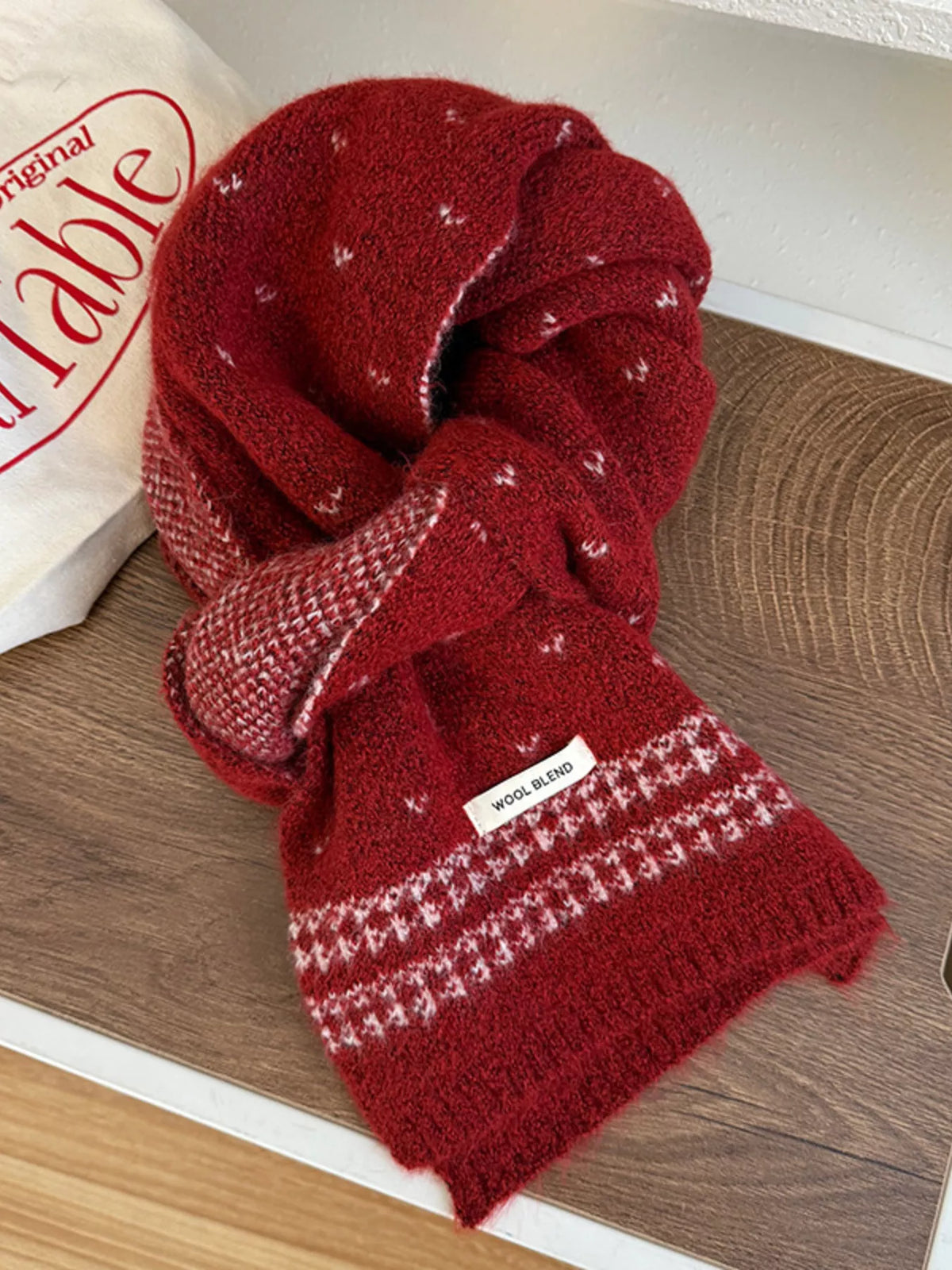 Unisex Flecked Border Knit Scarf — red scarf knotted on a pale surface