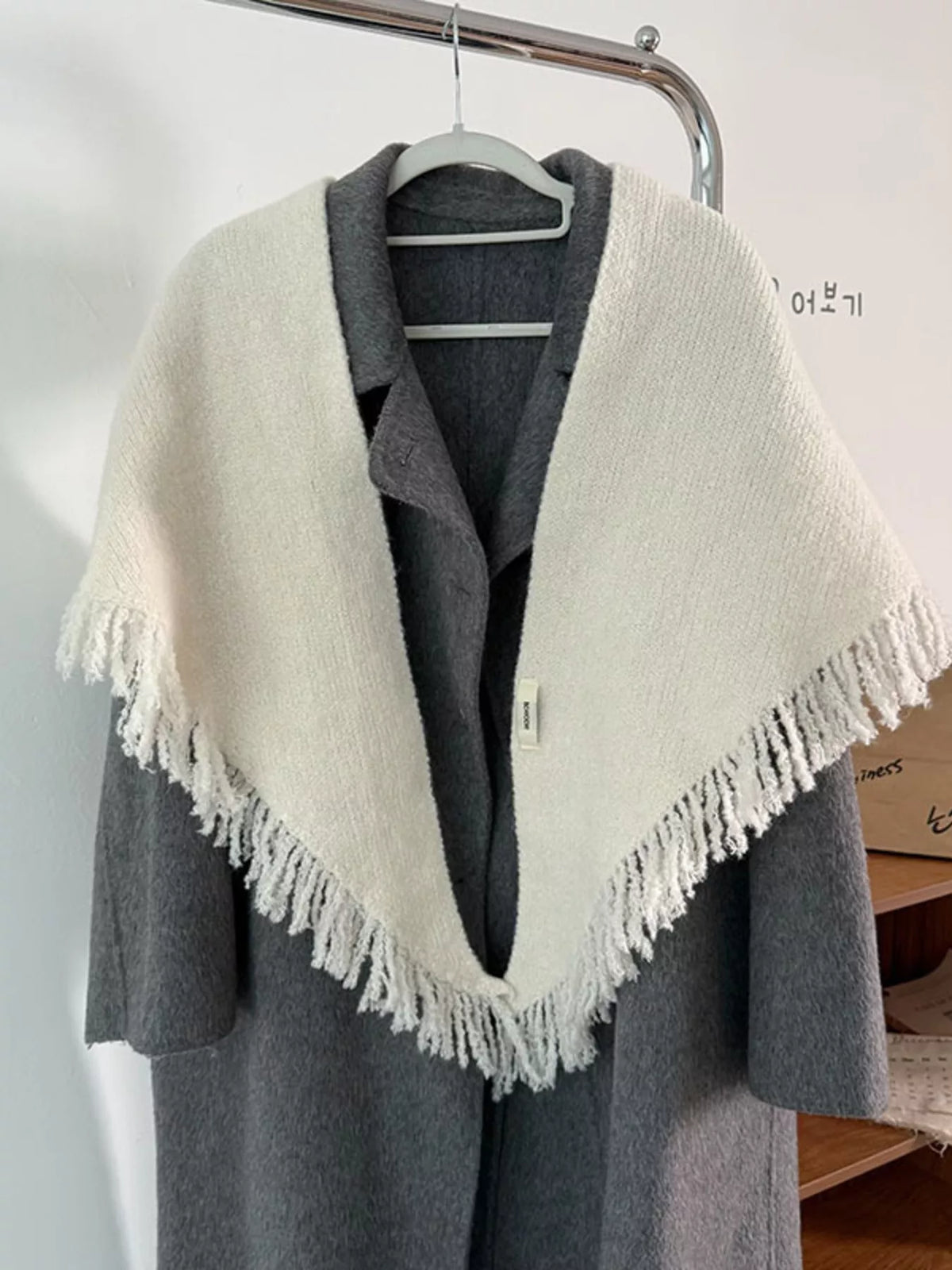 Women's Fringe Knit Triangle Wrap — pale fringed shawl draped over gray knitwear