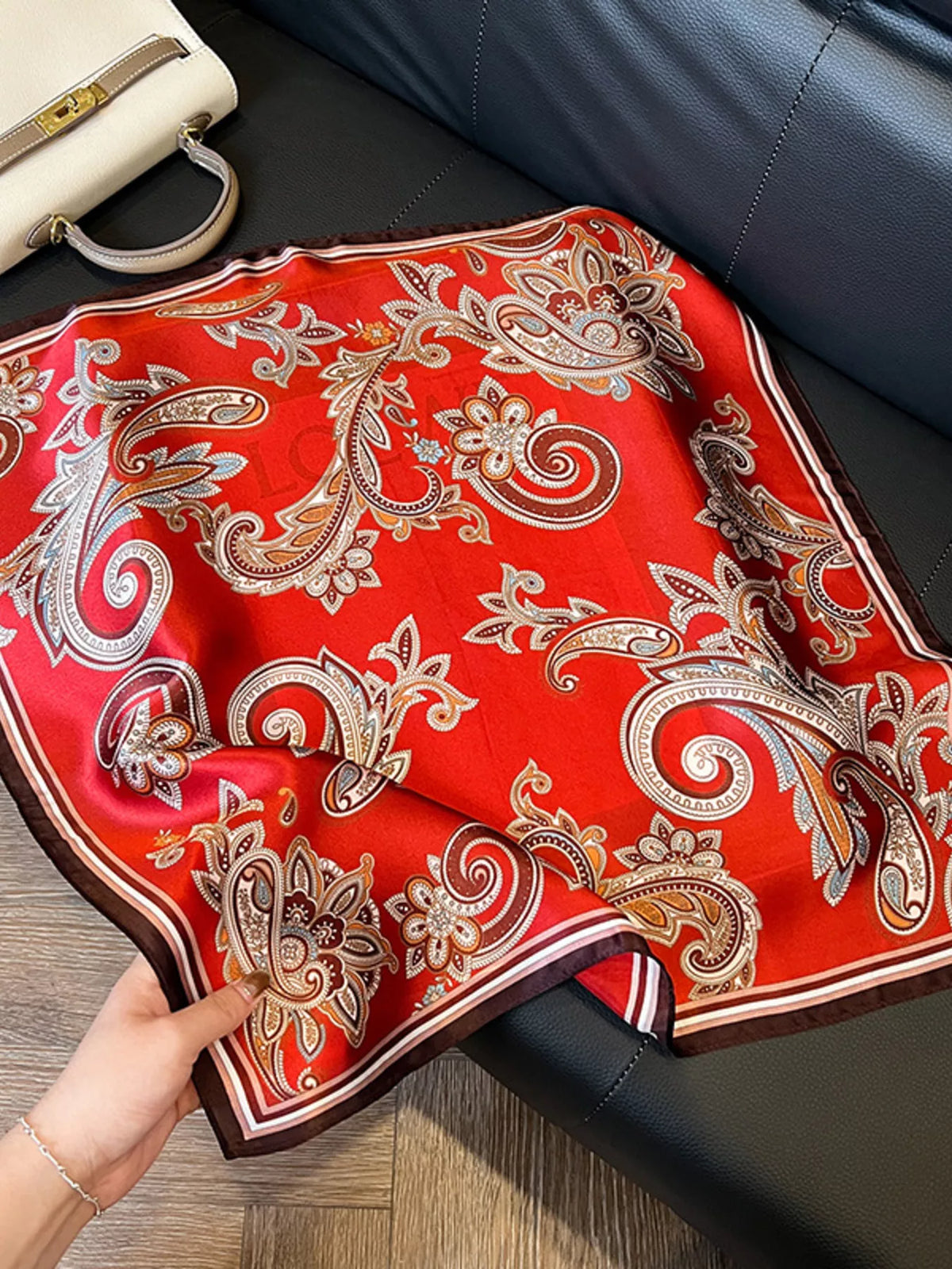 Unisex Vintage Paisley Silk Scarf — close handheld view of red paisley fabric