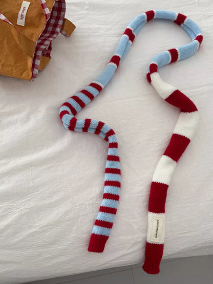 Unisex Red Stripe Skinny Scarf — red striped scarf loosely crossed on a pale surface