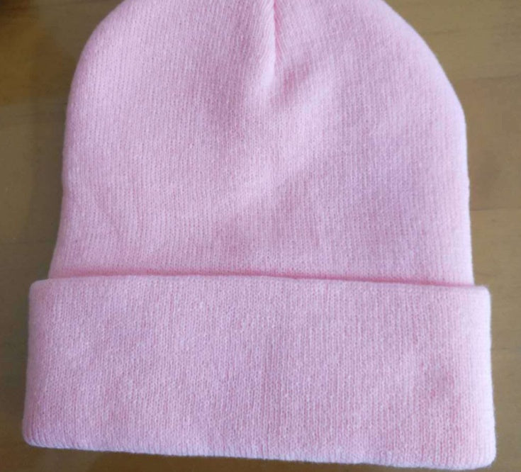 Pink cuffed knit beanie showing its plain rear surface