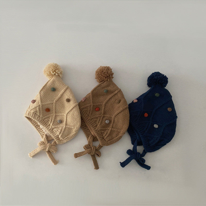 Beige coffee and navy earflap knit hats arranged together