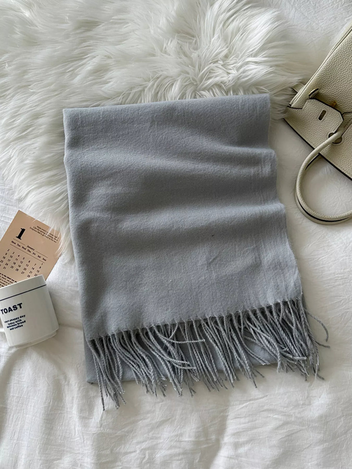 Unisex Long Soft Fringe Scarf — gray long scarf folded on a pale surface