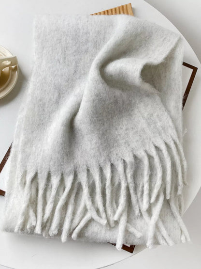 Unisex Extra Long Fringe Scarf — light gray scarf folded on a display tray