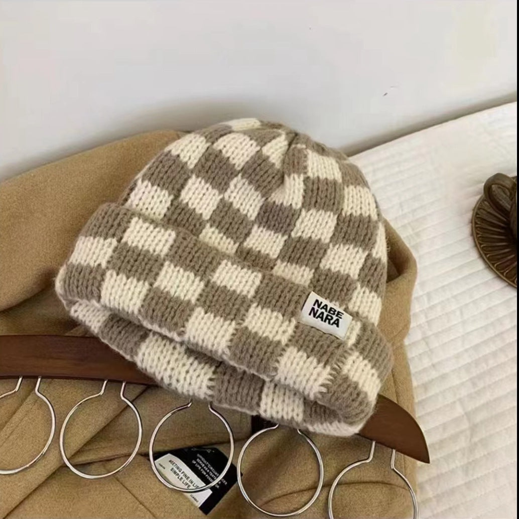 Beige khaki checkerboard beanie with a small front label