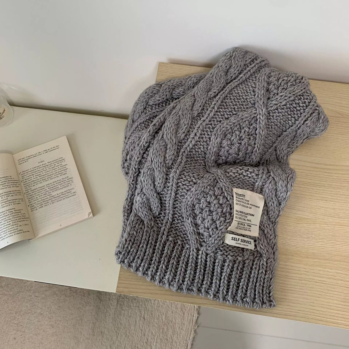 Unisex Chunky Cable Knit Scarf — gray chunky knit scarf draped beside a book