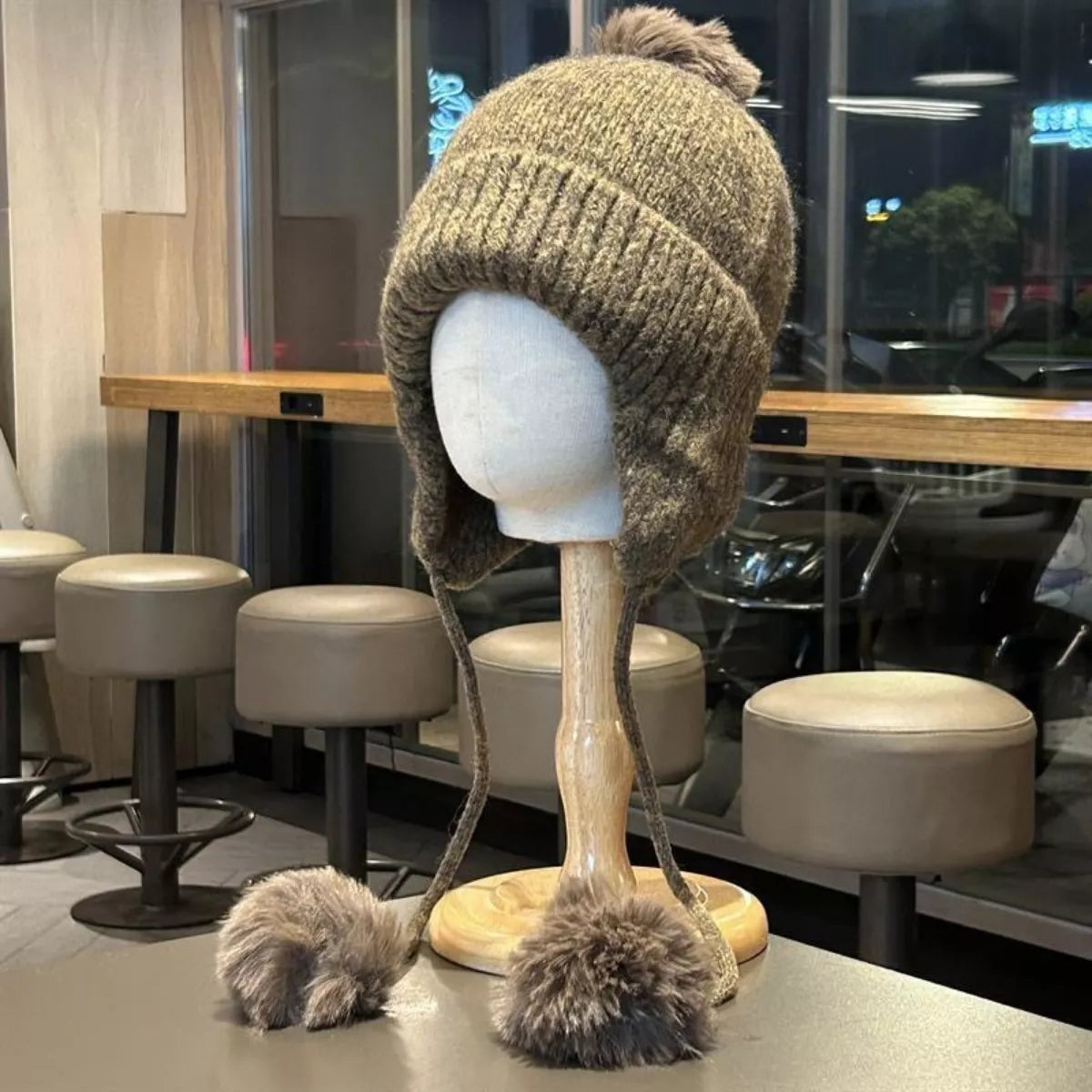 Gray pom pom ear flap beanie side view
