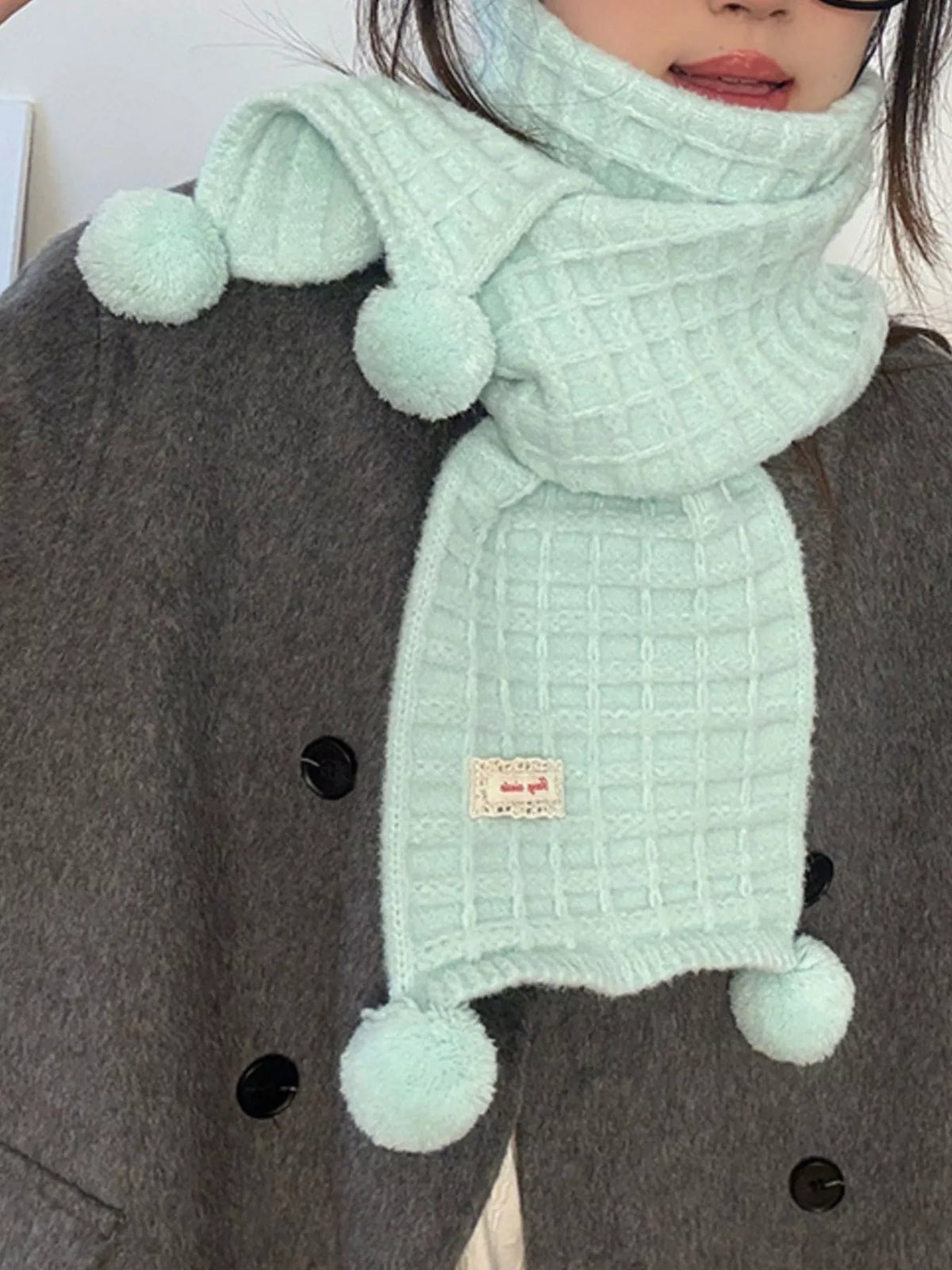 Unisex Pastel Waffle Knit Scarf — closer view of a mint waffle scarf tied over a coat