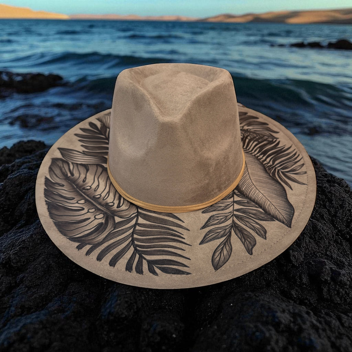 Light taupe botanical fedora photographed on coastal rocks