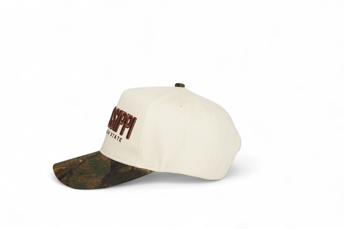Side profile of the Destination Hat Co. Mississippi camo cap showing the curved bill and side logo