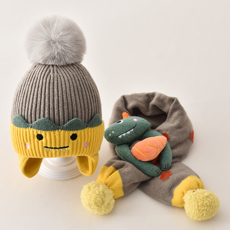 Gray and yellow pom pom beanie with a dinosaur scarf