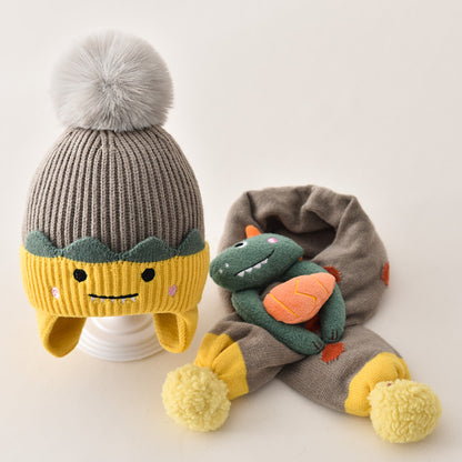Gray and yellow pom pom beanie with a dinosaur scarf